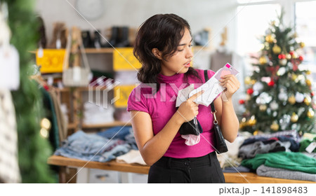Female shopper chooses socks in clothing store Female shopper chooses socks in clothing store 141898483
