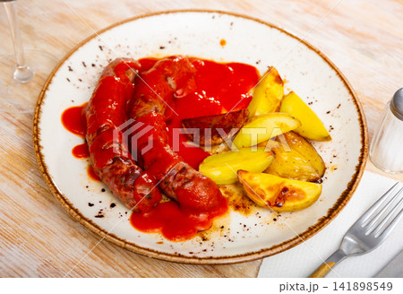 grilled sausages and slices of toasted potatoes grilled sausages and slices of toasted potatoes 141898549