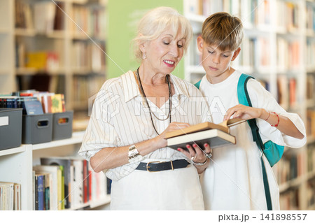 Happy grandmother with grandson choosing books in large bookstore 141898557