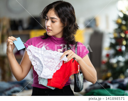 Asian woman chooses panties in clothing store before Christmas 141898571