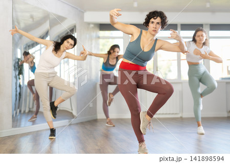 Female teacher conducts modern dance lessons for group of girls 141898594