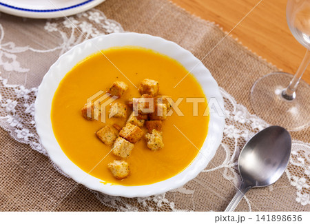Yellow carrot mousse is decorated with small toasted crispy croutons 141898636