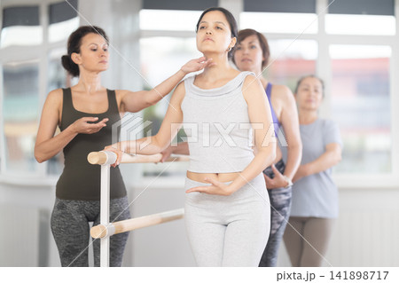Choreographer coach teaches amateur students to keep their heads straight during ballet lesson 141898717