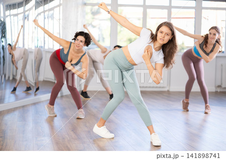 Young female teacher conducts modern dance lessons for group of girls 141898741