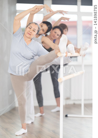Group of women stretching at ballet barre 141898785