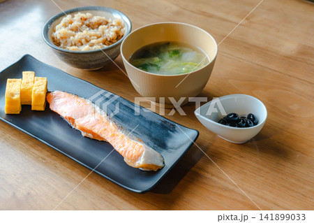 和朝食の定食。焼鮭、卵焼き、味噌汁、黒豆、ご飯。 141899033