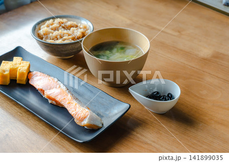 和朝食の定食。焼鮭、卵焼き、味噌汁、黒豆、ご飯。 141899035