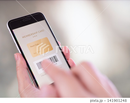 スマホでデジタル会員証・会員カードのモバイルアプリを提示する手元写真。画面はオリジナルのイメージ画像 スマホでデジタル会員証・会員カードのモバイルアプリを提示する手元写真。画面はオリジナルのイメージ画像 141901248