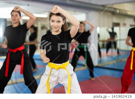 Female athletes in black suit standing in formation, kata starting position. Female athletes in black suit standing in formation, kata starting position. 141902419