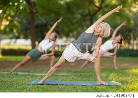 Elderly woman doing yoga in park Elderly woman doing yoga in park 141902471
