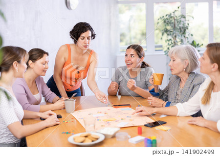 Young female moderator throws stones and determines order of parties in board game Young female moderator throws stones and determines order of parties in board game 141902499