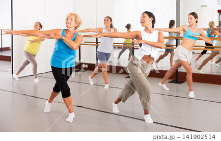 Women performing contemporary dance in training room Women performing contemporary dance in training room 141902514