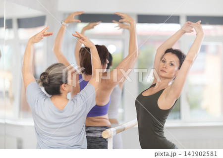 Adult woman teacher showing ballet movements Adult woman teacher showing ballet movements 141902581
