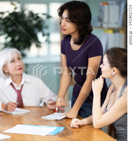 Young girl leading a group discussion at table 141902733