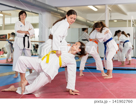 Women practice judo techniques in pairs 141902760