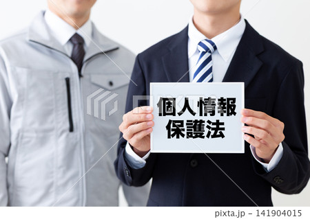 個人情報保護法のホワイトボードを持つリクルートスーツを着た若い男性ビジネスマン 141904015