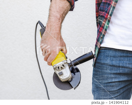 Handsome man, angle grinder and work clothes Handsome man, angle grinder and work clothes 141904112