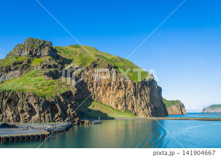 Heimaklettur cliff and harbor in Heimaey island, Iceland Heimaklettur cliff and harbor in Heimaey island, Iceland 141904667