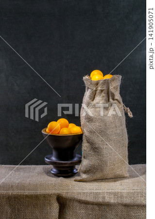 A bag and a vase filled with yellow marbles. A bag and a vase filled with yellow marbles. 141905071