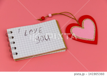 Heart and notepad with handwritten text " I Love You" on pastel pink background. Valentine Day concept 141905360