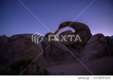 Majestic natural arch rock formation under peaceful night sky in sierra nevada desert landscape offers serene wondrous emotion Majestic natural arch rock formation under peaceful night sky in sierra nevada desert landscape offers serene wondrous emotion 141905920