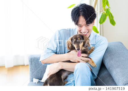 ファミリー 犬のいる暮らし ソファーでくつろぐ男性と犬 ファミリー 犬のいる暮らし ソファーでくつろぐ男性と犬 141907519