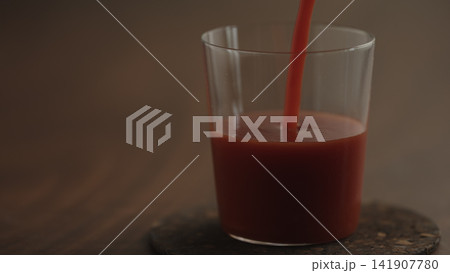 pour tomato juice in a glass closeup pour tomato juice in a glass closeup 141907780