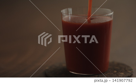 pour tomato juice in a glass closeup pour tomato juice in a glass closeup 141907792