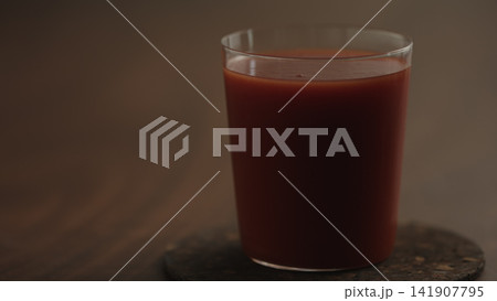 pour tomato juice in a glass closeup pour tomato juice in a glass closeup 141907795
