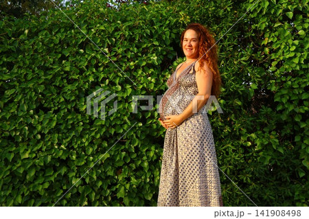 Pregnant Woman Enjoying a Peaceful Outdoor Moment Pregnant Woman Enjoying a Peaceful Outdoor Moment 141908498