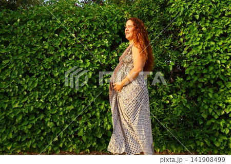 Pregnant Woman Enjoying a Peaceful Outdoor Moment Pregnant Woman Enjoying a Peaceful Outdoor Moment 141908499
