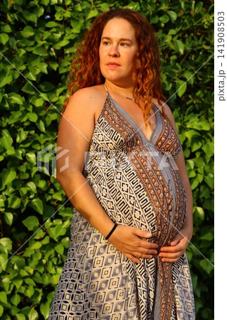 Pregnant Woman Enjoying a Peaceful Outdoor Moment Pregnant Woman Enjoying a Peaceful Outdoor Moment 141908503