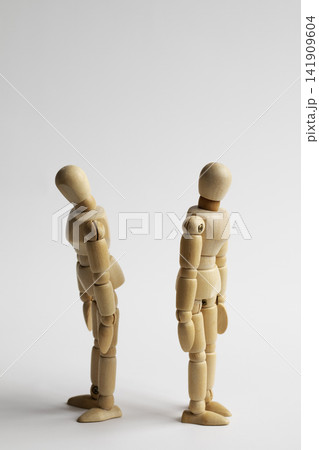 Two wooden figures with their backs to each other 141909604