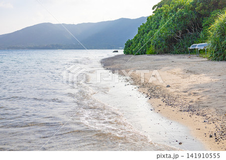 南国リゾートのバカンス・ビーチの小石が荒々しい夕方の海・ビーチ・穏やかな浜辺（鹿児島県奄美大島） 141910555
