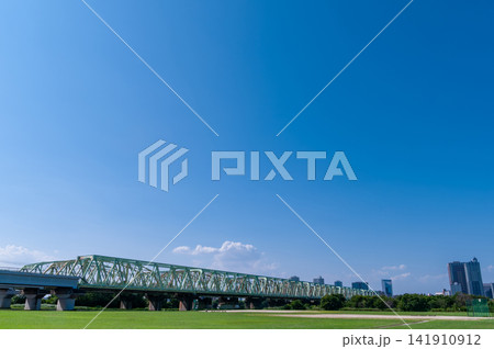青空と川沿いの鉄橋　緑の風景　コピースペースのある背景素材 141910912