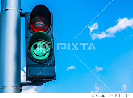Green traffic light with smiley face symbol against clear blue sky, positive road safety and urban concept Green traffic light with smiley face symbol against clear blue sky, positive road safety and urban concept 141911195
