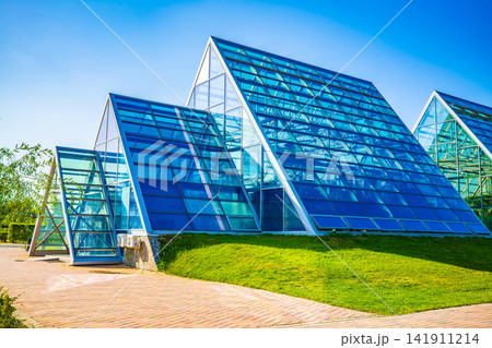 Blue glass greenhouse building against clear blue sky in Astana botanical garden, Kazakhstan Blue glass greenhouse building against clear blue sky in Astana botanical garden, Kazakhstan 141911214