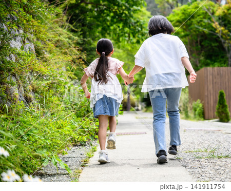 姉妹が手をつないで駆けていく後ろ姿 姉妹が手をつないで駆けていく後ろ姿 141911754