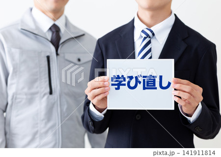 学び直しのホワイトボードを持つリクルートスーツを着た若い男性ビジネスマン 学び直しのホワイトボードを持つリクルートスーツを着た若い男性ビジネスマン 141911814