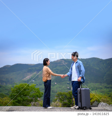 旅行先で握手をする若い男女のカップル 旅行先で握手をする若い男女のカップル 141911825