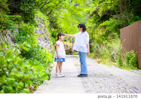 緑豊かな小道で頭をなでる姉妹 緑豊かな小道で頭をなでる姉妹 141911870