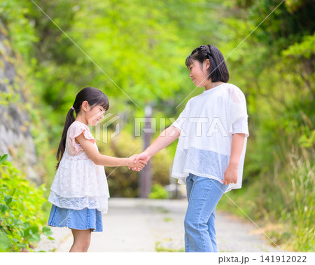 手をつないで歩く仲の良い姉妹 141912022