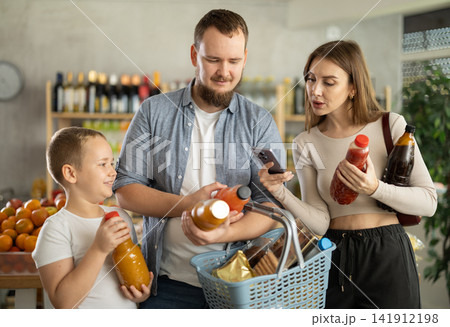Couple of man and woman with boy scanning qr code of juices 141912198