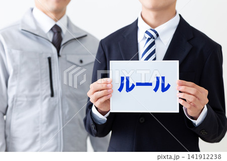 ルールのホワイトボードを持つリクルートスーツを着た若い男性ビジネスマン 141912238