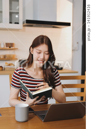 Asian woman using computer remote for business studying, watching online virtual webinar training meeting, video call. asian business woman talking on laptop in home office. Banner, copy space 141912416