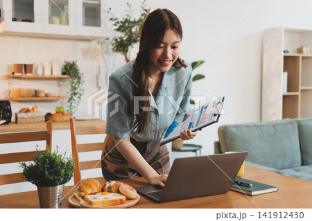 Young adult asian business woman using laptop chat digital artificial intelligence assistance ai chatbot prompt analysis work modern lifestyles 141912430
