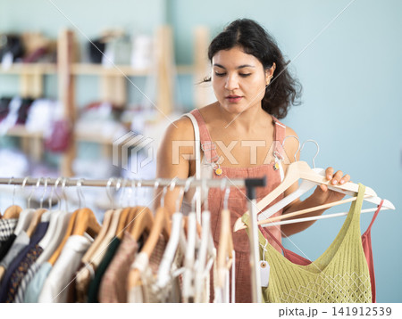 Girl at trading floor pick out and buying sundress or tank top 141912539