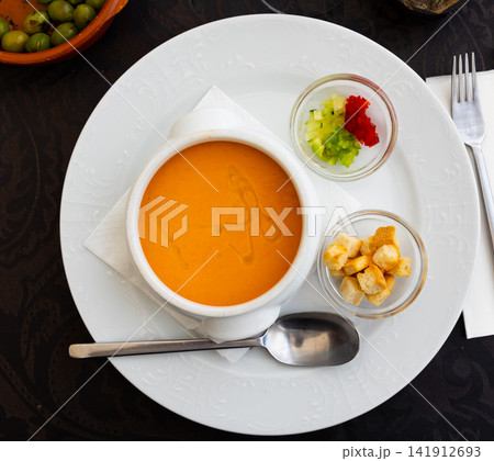 Traditional Spanish cuisine, gaspacho or gazpacho cold soup with vegetables and baked breads Traditional Spanish cuisine, gaspacho or gazpacho cold soup with vegetables and baked breads 141912693