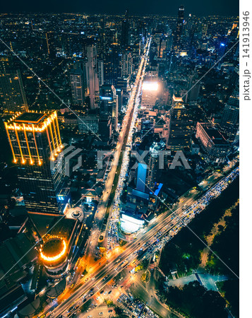 Bangkok city skyline and illuminated high-rise skyscraper buildings, Night cityscape of downtown financial district with illuminated modern urban towers of Thailand capital Bangkok city skyline and illuminated high-rise skyscraper buildings, Night cityscape of downtown financial district with illuminated modern urban towers of Thailand capital 141913946