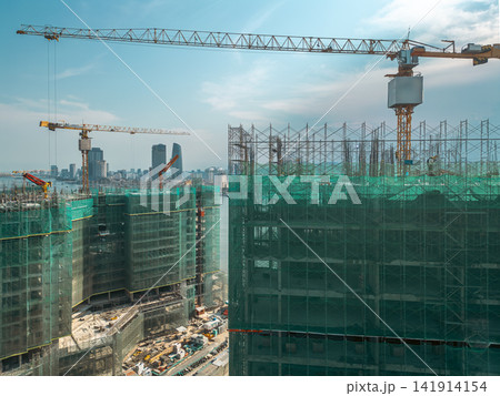 Modern construction site with tower cranes and high-rise buildings under development, Urban skyline growth with scaffolding and green safety mesh, Da Nang Danang Vietnam 141914154